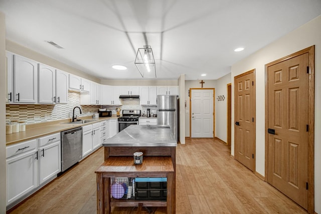 100 N Bokelman St Unit 430, Roselle, IL 60172 - kitchen with appliances with stainless steel finishes, a sink, stainless steel counters, under cabinet range hood, and light wood finished floors