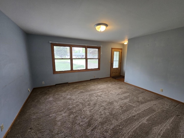 spare room featuring baseboards and carpet flooring