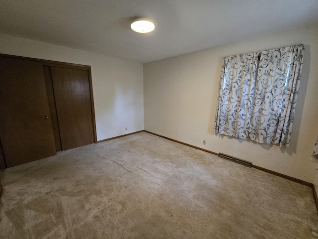 unfurnished bedroom featuring baseboards, light carpet, a closet, and visible vents