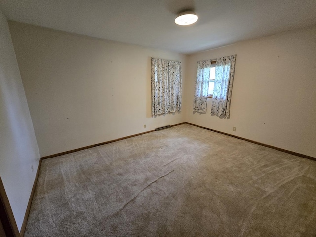 carpeted spare room with baseboards and visible vents