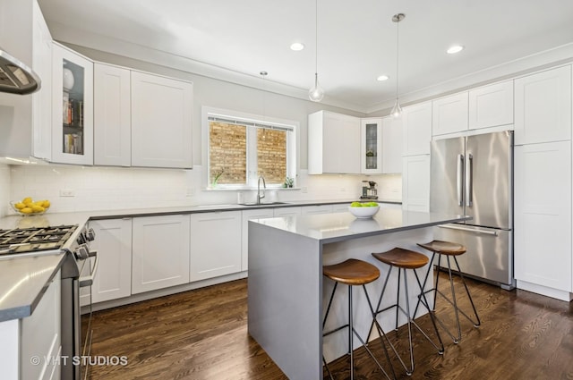 5263 N Laporte Ave, Chicago, IL 60630 - kitchen featuring stainless steel appliances, a sink, a kitchen bar, dark wood-style flooring, and recessed lighting