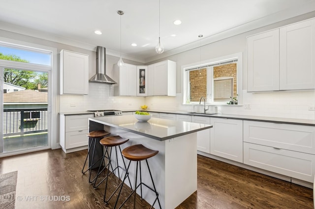 5263 N Laporte Ave, Chicago, IL 60630 - kitchen with wall chimney exhaust hood, a sink, a breakfast bar area, tasteful backsplash, and crown molding