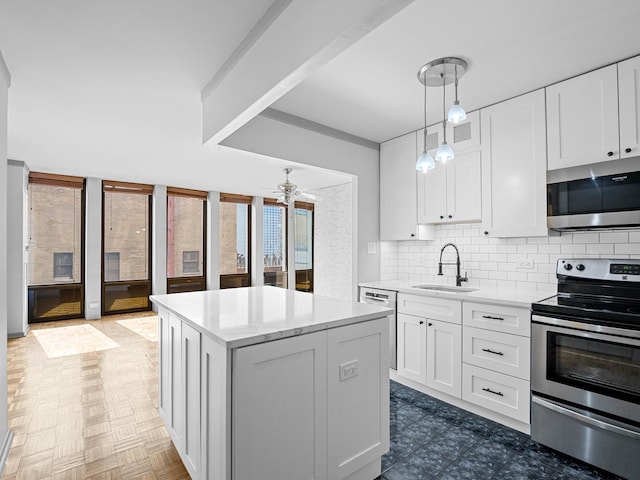 100 E Walton St Unit 18G, Chicago, IL 60611 - kitchen with stainless steel appliances, a sink, decorative backsplash, a center island, and a ceiling fan