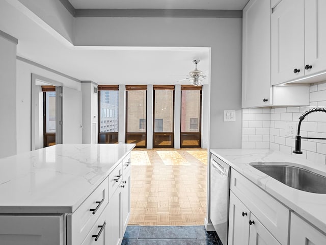 100 E Walton St Unit 18G, Chicago, IL 60611 - kitchen with stainless steel dishwasher, a sink, a ceiling fan, decorative backsplash, and light stone countertops