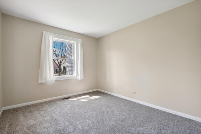 carpeted spare room featuring baseboards