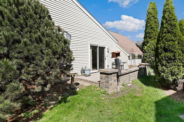 rear view of property with a yard and a patio