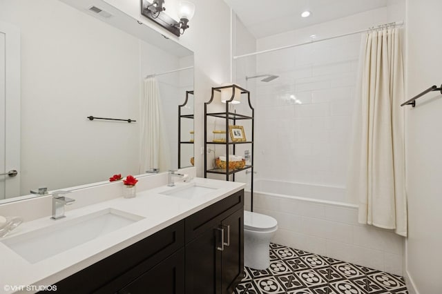 bathroom with tiled shower / bath combo, tile patterned floors, toilet, double vanity, and recessed lighting