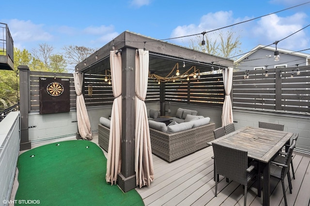 deck with a putting area, an outdoor living space, and fence