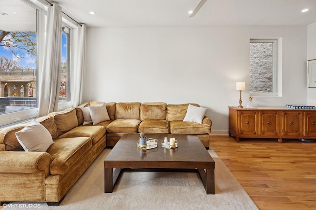 living room featuring light wood-style flooring, recessed lighting, and baseboards