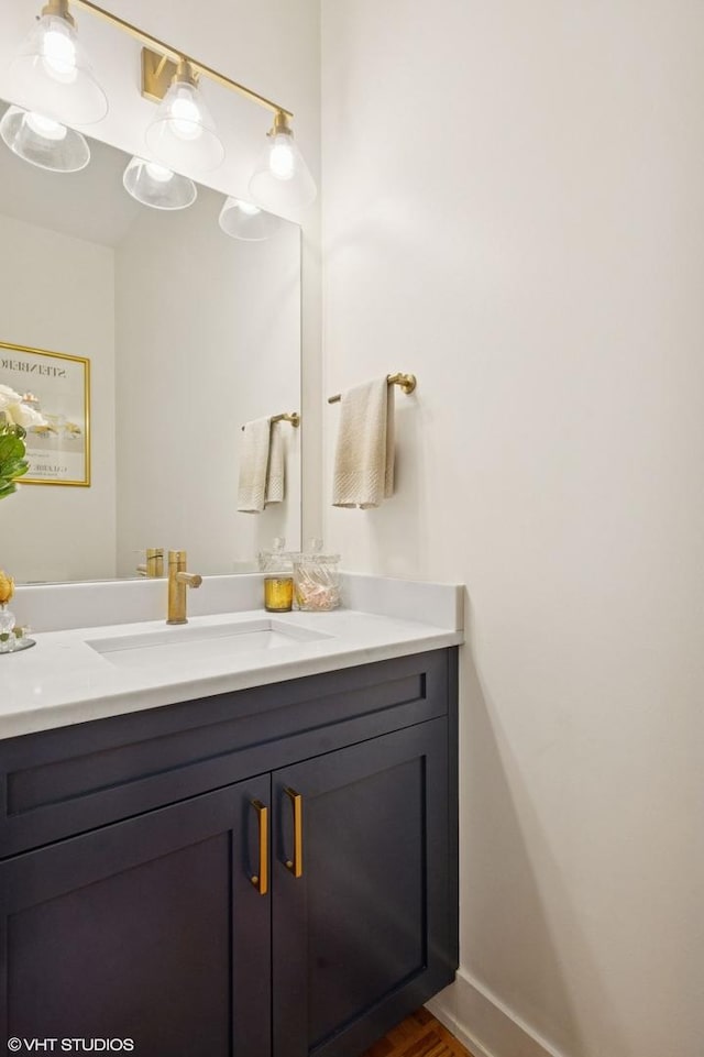 bathroom with vanity, wood finished floors, and baseboards