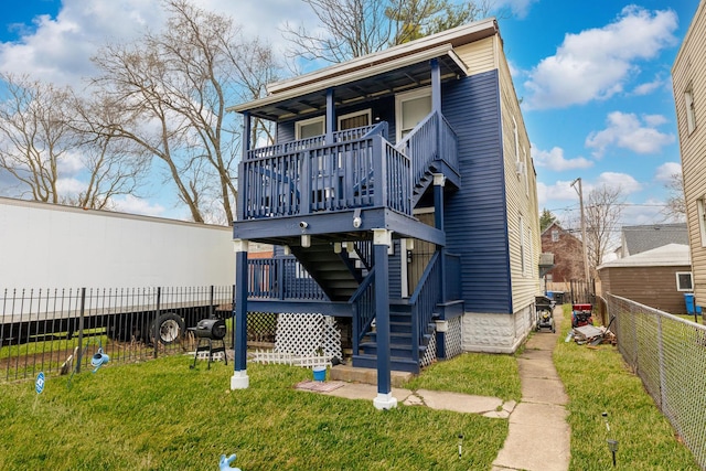 rear view of house with a lawn, stairs, and a fenced backyard