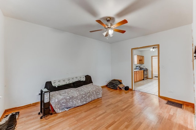 bedroom featuring ceiling fan, baseboards, light wood-type flooring, and visible vents