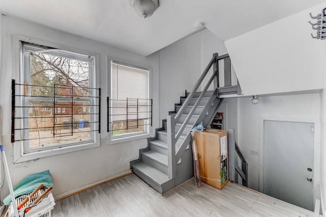 stairway with a wealth of natural light and wood finished floors