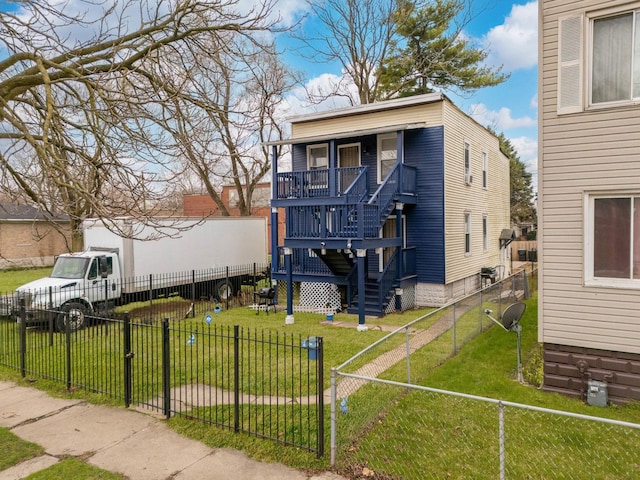 view of front facade featuring a front yard, stairway, covered porch, and a fenced backyard
