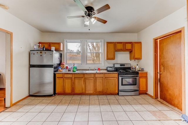 kitchen with stainless steel appliances, baseboards, a ceiling fan, and brown cabinets