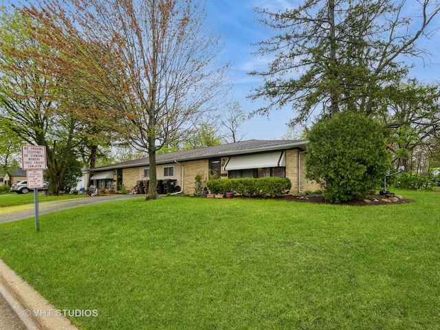 ranch-style home with a front lawn, brick siding, and driveway