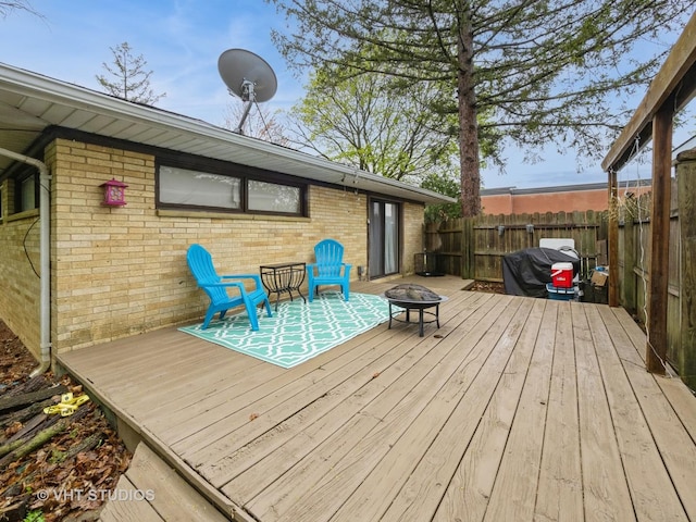 deck featuring an outdoor fire pit, fence, and area for grilling