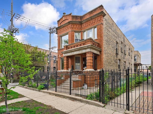 exterior space with a fenced front yard, a gate, and brick siding