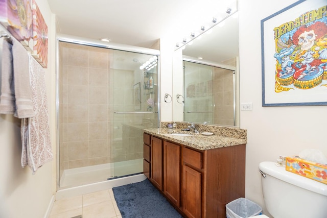 bathroom featuring tile patterned floors, a shower stall, vanity, and toilet