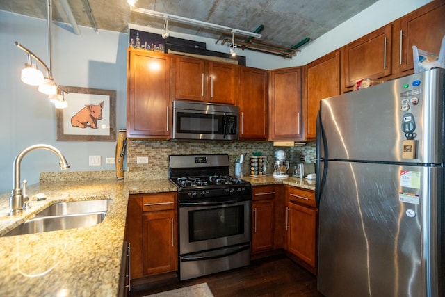 kitchen with stainless steel appliances, a sink, dark wood-type flooring, light stone counters, and tasteful backsplash