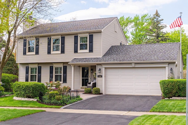 view of front facade featuring asphalt driveway, a garage, and roof with shingles