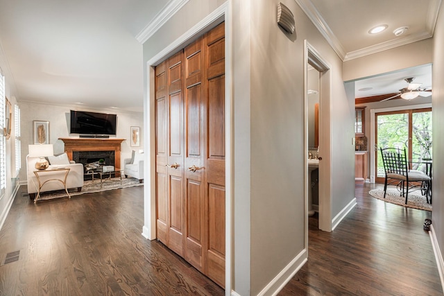 corridor with ornamental molding, dark wood-type flooring, baseboards, and recessed lighting