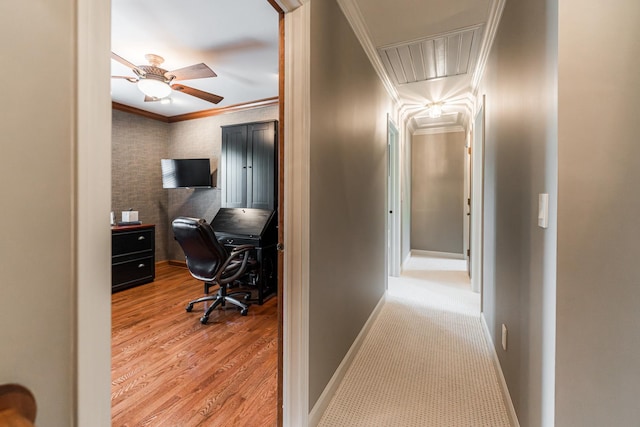 corridor with attic access, crown molding, baseboards, and wood finished floors