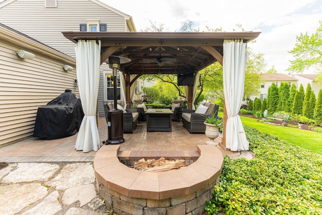 view of patio / terrace featuring a gazebo, an outdoor living space with a fire pit, and a ceiling fan