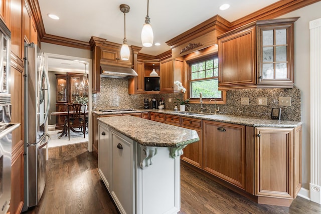 kitchen with a sink, a kitchen island, brown cabinetry, tasteful backsplash, and ornamental molding