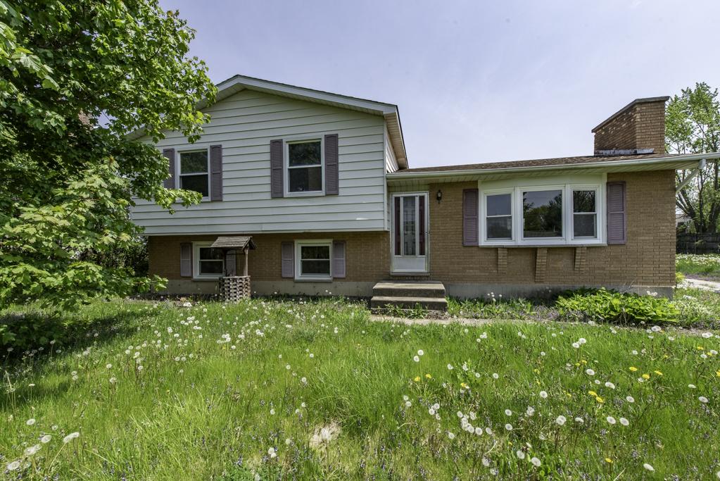 38815 N Pine Grove Ave, Wadsworth, IL 60083 - split level home with brick siding, a chimney, and entry steps