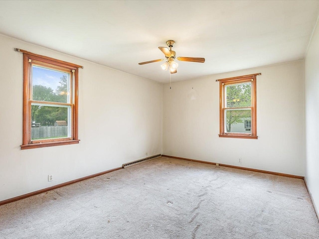 spare room featuring baseboards, a baseboard heating unit, ceiling fan, and carpet floors