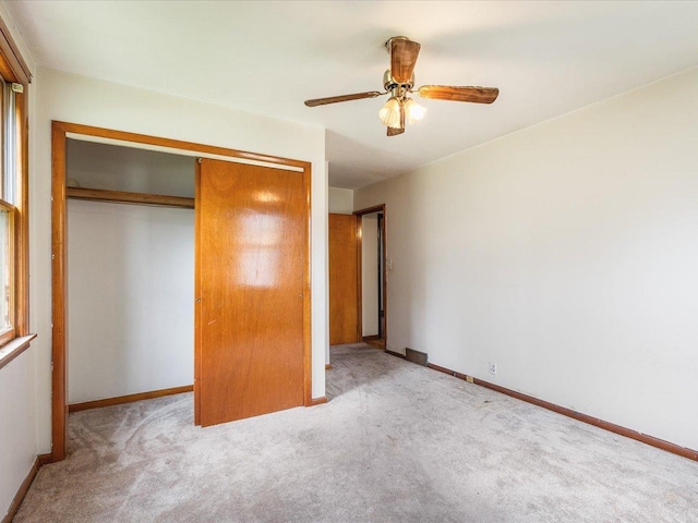 unfurnished bedroom with baseboards, carpet flooring, a closet, and ceiling fan
