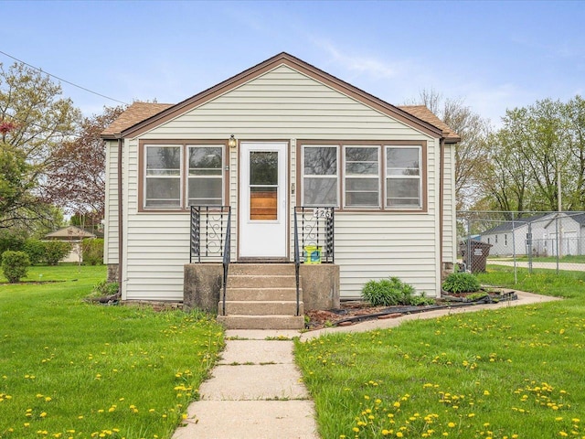 bungalow featuring fence and a front lawn