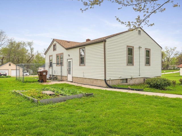 back of property with a chimney, fence, and a lawn