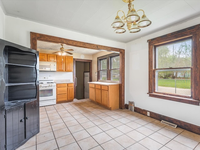 kitchen featuring a notable chandelier, a wealth of natural light, visible vents, and white appliances