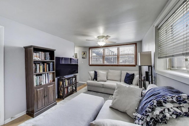living area featuring a ceiling fan, wood finished floors, and baseboards