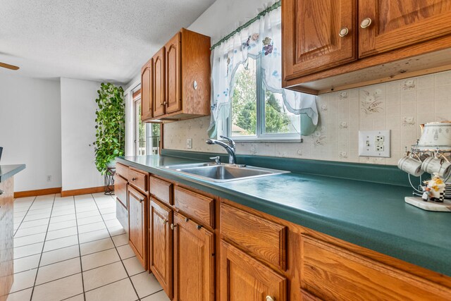 2503 Maplewood Dr, Champaign, IL 61821 - kitchen with a sink, brown cabinets, light tile patterned floors, tasteful backsplash, and dark countertops