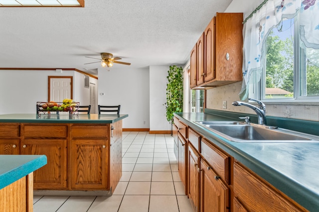 2503 Maplewood Dr, Champaign, IL 61821 - kitchen featuring a sink, brown cabinets, light tile patterned flooring, ceiling fan, and a textured ceiling