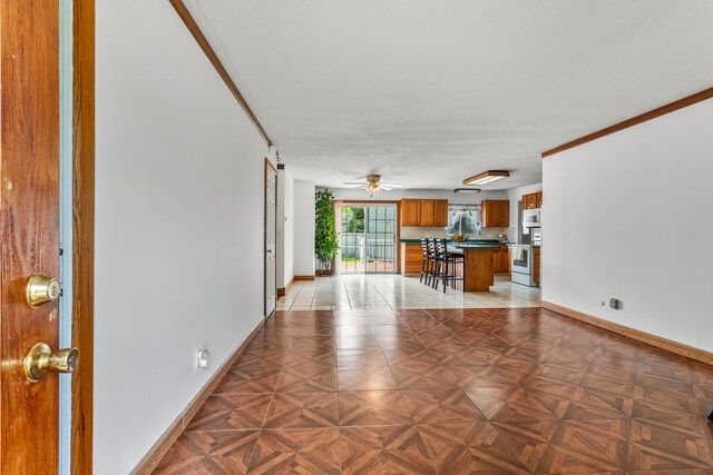 2503 Maplewood Dr, Champaign, IL 61821 - unfurnished living room featuring baseboards, a ceiling fan, and crown molding