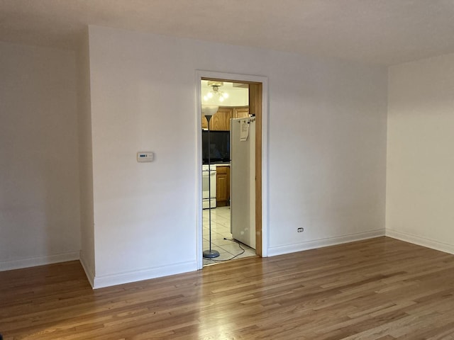 empty room featuring light wood finished floors and baseboards