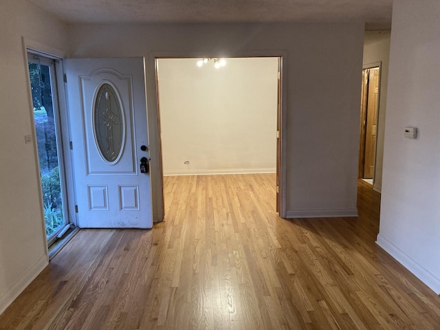 foyer entrance with wood finished floors and baseboards