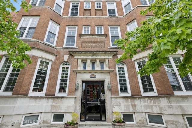 view of exterior entry featuring brick siding