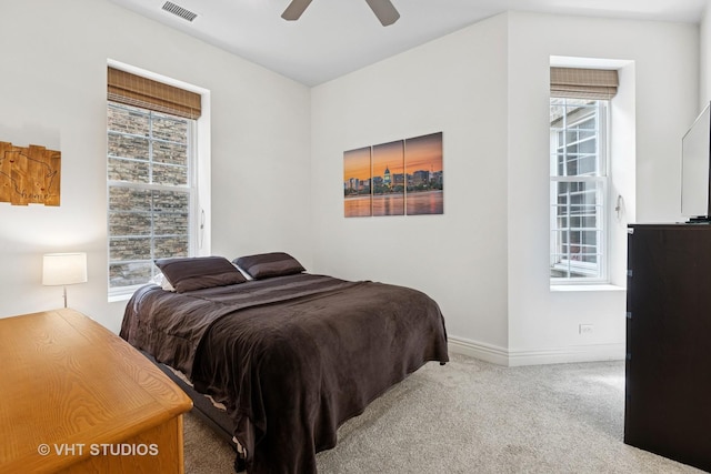 bedroom featuring carpet flooring, multiple windows, baseboards, and ceiling fan