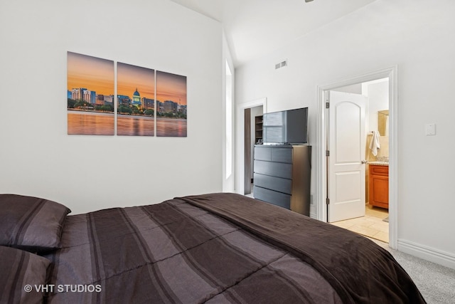 bedroom featuring light carpet, baseboards, and connected bathroom