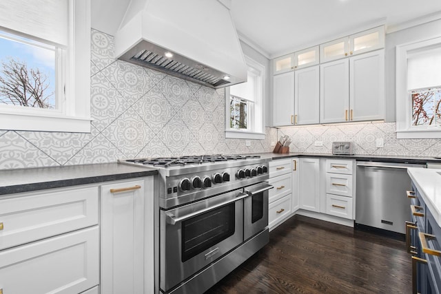 15 Reliance Ln, Lincolnshire, IL 60069 - kitchen featuring appliances with stainless steel finishes, custom range hood, dark countertops, white cabinetry, and dark wood finished floors