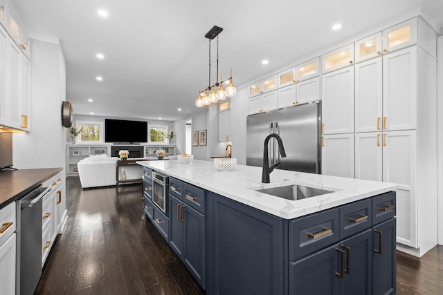 15 Reliance Ln, Lincolnshire, IL 60069 - kitchen with appliances with stainless steel finishes, a sink, blue cabinetry, an island with sink, and dark wood finished floors