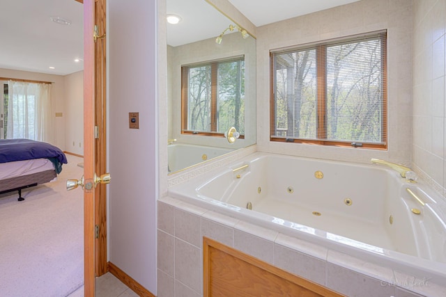 full bath with ensuite bathroom, a tub with jets, baseboards, and tile patterned flooring
