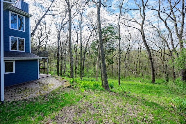 view of yard featuring a view of trees and a patio