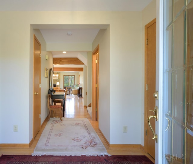 hall featuring baseboards, light wood-style floors, and recessed lighting
