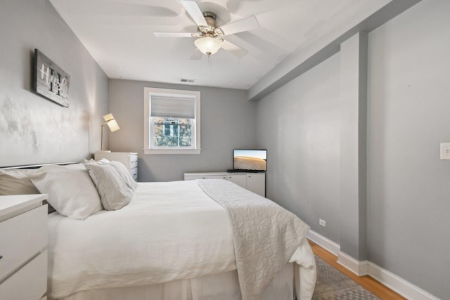 bedroom featuring light wood-style floors, baseboards, and a ceiling fan